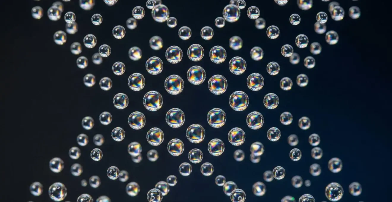 Vue macro de gouttelettes de vapeur transparentes suspendues dans l'air avec reflets arc-en-ciel